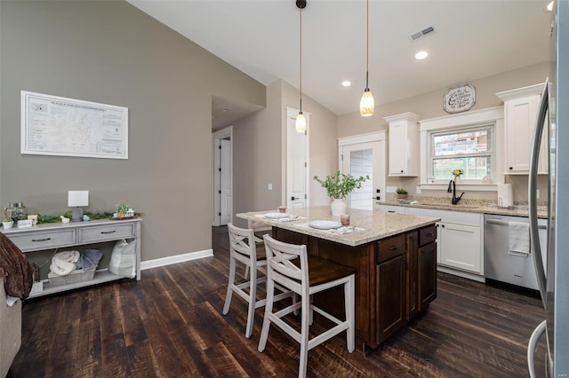 kitchen featuring stainless steel dishwasher, dark wood-type flooring, a kitchen island, and vaulted ceiling