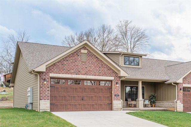 view of front of home with a porch, a front lawn, and a garage