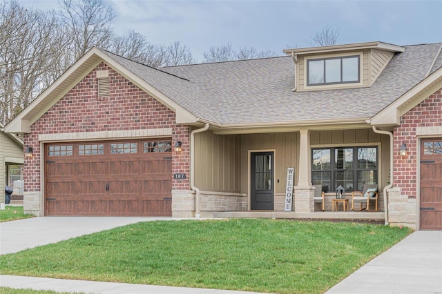 view of front of home with a porch, a front lawn, and a garage