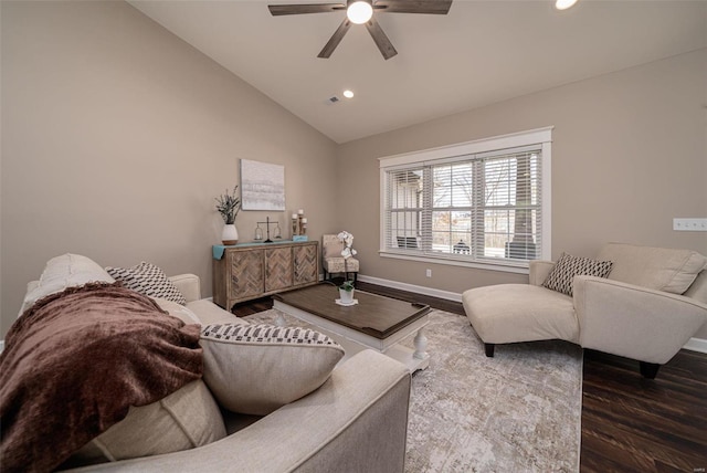 living room with dark hardwood / wood-style flooring, ceiling fan, and vaulted ceiling