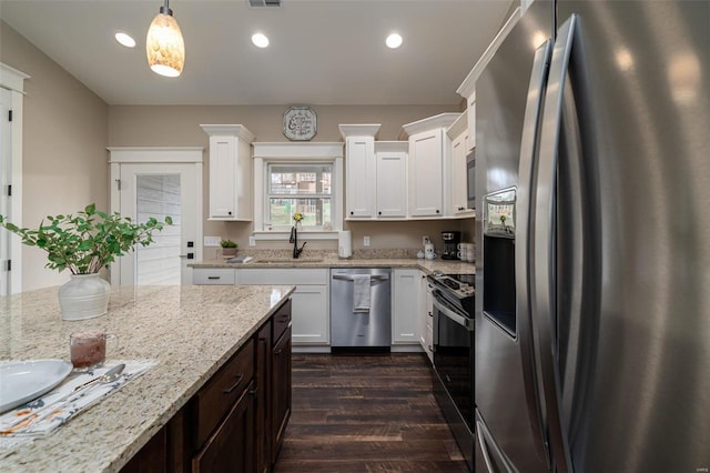 kitchen featuring pendant lighting, appliances with stainless steel finishes, white cabinetry, and sink