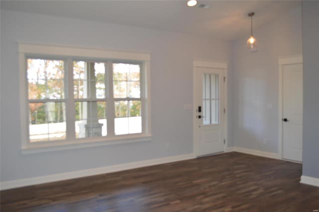 foyer entrance featuring dark wood-type flooring and vaulted ceiling