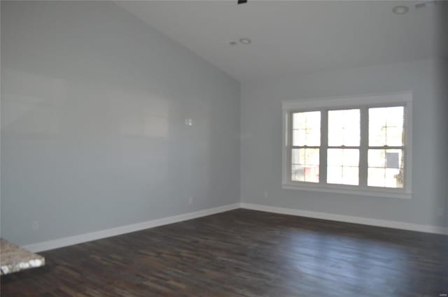 empty room with dark hardwood / wood-style flooring and lofted ceiling