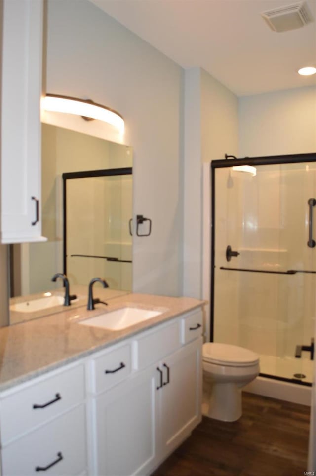 bathroom featuring hardwood / wood-style floors, an enclosed shower, vanity, and toilet