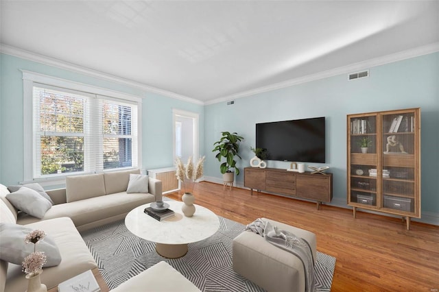 living room with hardwood / wood-style floors and crown molding