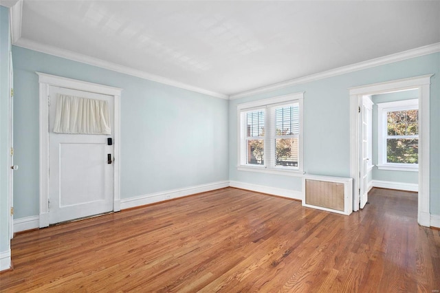 empty room with a wealth of natural light, ornamental molding, and hardwood / wood-style flooring