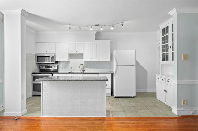 kitchen with white cabinets, light hardwood / wood-style flooring, crown molding, a kitchen island, and appliances with stainless steel finishes