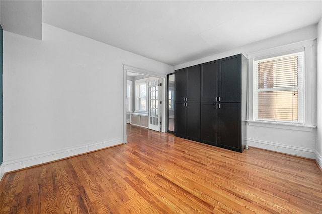 unfurnished bedroom featuring light hardwood / wood-style floors and multiple windows