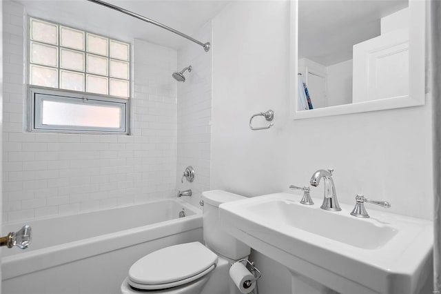 bathroom with toilet and tiled shower / bath