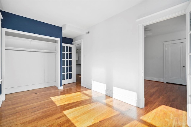 unfurnished bedroom featuring wood-type flooring and a closet