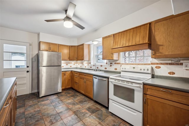 kitchen featuring backsplash, stainless steel appliances, ceiling fan, and sink