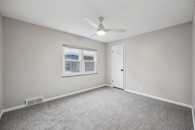 carpeted spare room featuring ceiling fan