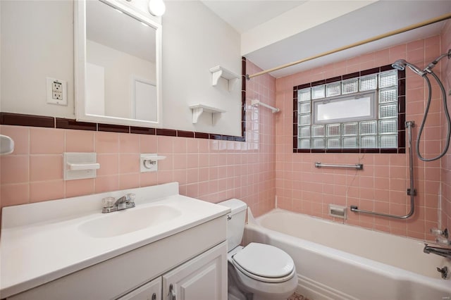 full bathroom with vanity, tiled shower / bath combo, tile walls, and toilet