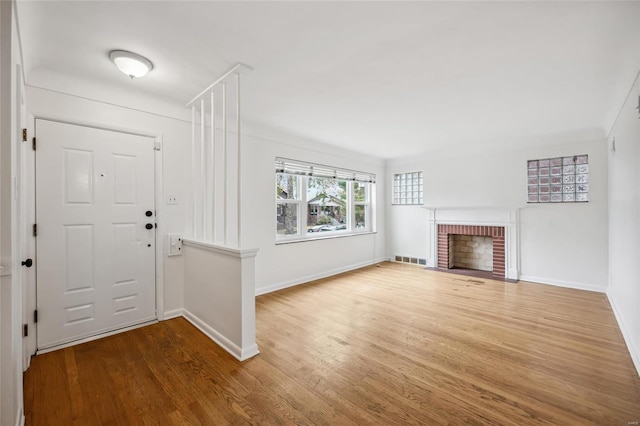 entrance foyer with wood-type flooring and a fireplace