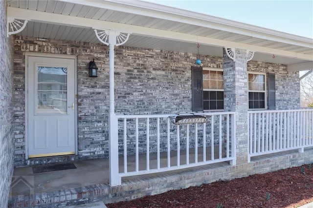 property entrance featuring brick siding and covered porch