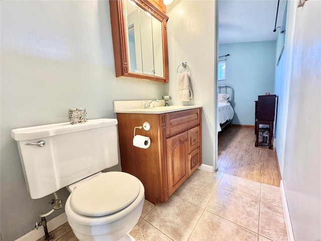 bathroom featuring tile patterned flooring, vanity, and toilet