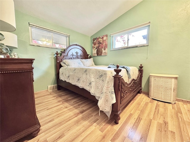 bedroom with light hardwood / wood-style floors and lofted ceiling