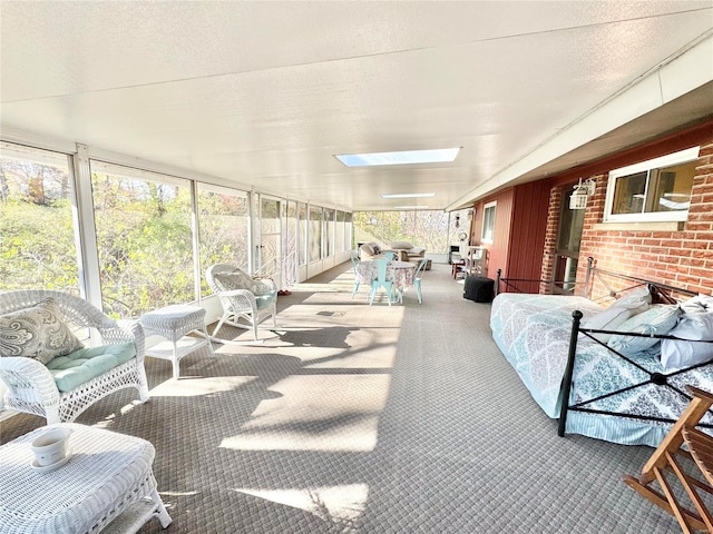 sunroom featuring lofted ceiling with skylight