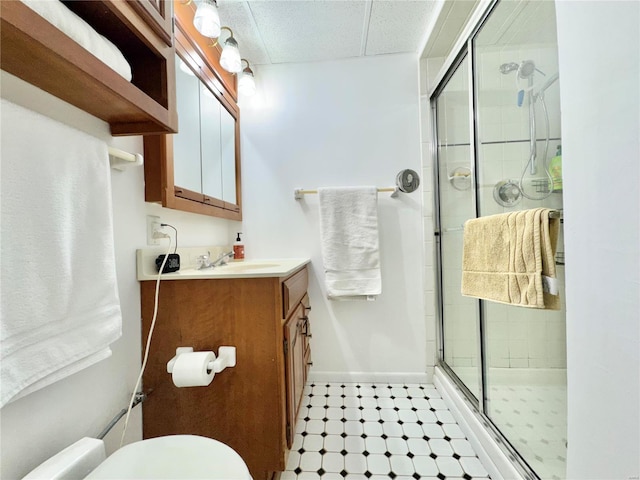 bathroom with vanity, toilet, and a shower with door