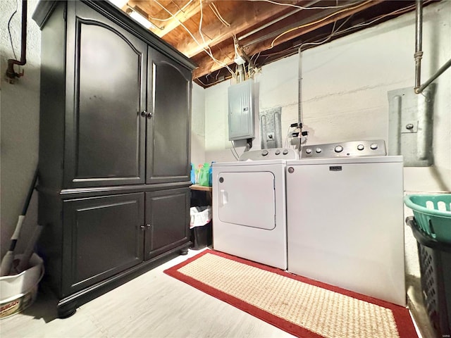 laundry room with cabinets, electric panel, and separate washer and dryer