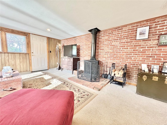 living room featuring a textured ceiling, brick wall, light carpet, and wooden walls