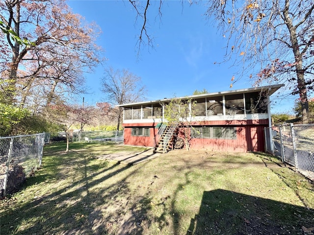 rear view of property with a yard and a sunroom