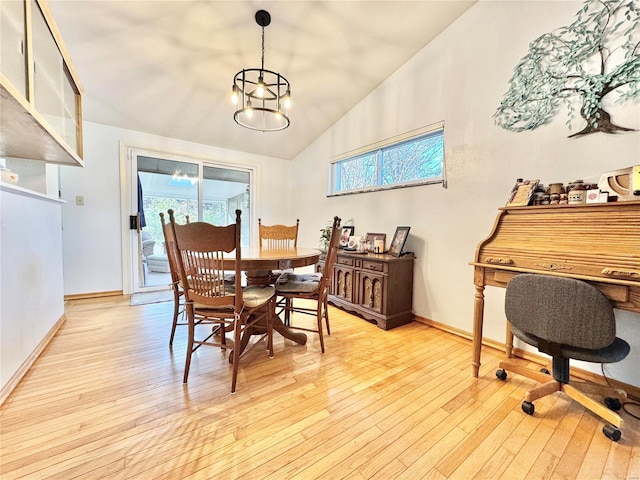 dining area featuring lofted ceiling, light wood-type flooring, and an inviting chandelier