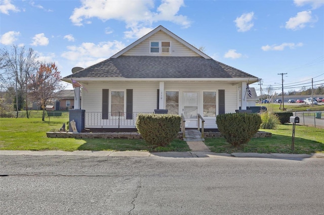 bungalow-style home featuring covered porch and a front lawn