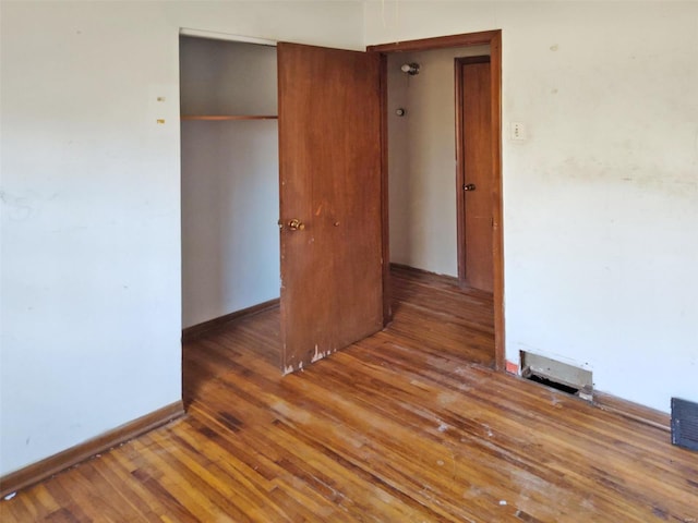 unfurnished bedroom featuring dark wood-type flooring and a closet