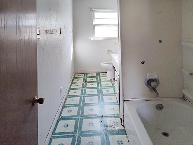 bathroom featuring tile patterned flooring, vanity, and a washtub