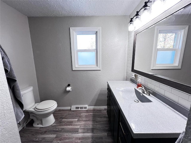 bathroom featuring vanity, toilet, hardwood / wood-style floors, and a textured ceiling