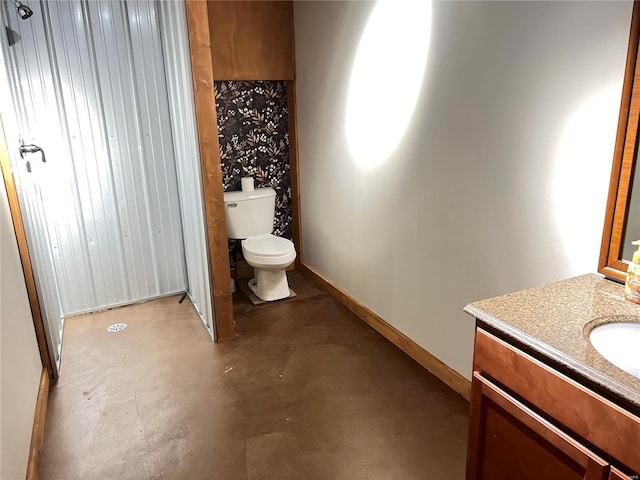 bathroom featuring vanity, concrete flooring, and toilet