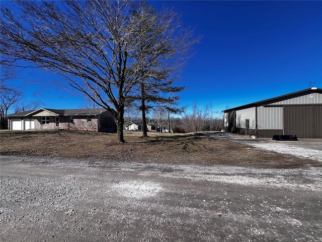 view of yard featuring a pole building, an outdoor structure, and an attached garage