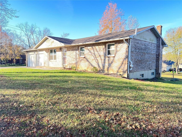 exterior space with a garage, a yard, brick siding, and a chimney