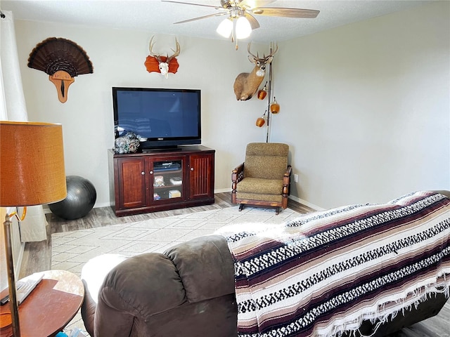 living room with light wood-style flooring, baseboards, and ceiling fan