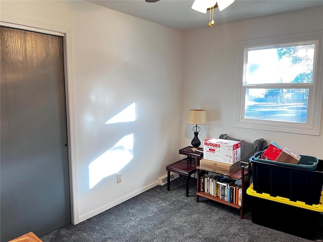 interior space featuring ceiling fan, dark carpet, and baseboards