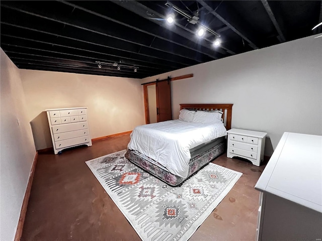 bedroom with concrete flooring, baseboards, and track lighting