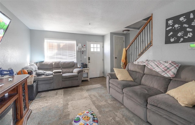 living room featuring a textured ceiling and carpet flooring