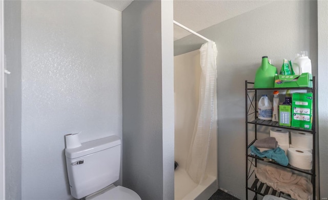 bathroom featuring toilet and a shower with curtain