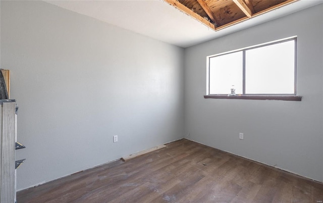 unfurnished room with dark wood-type flooring