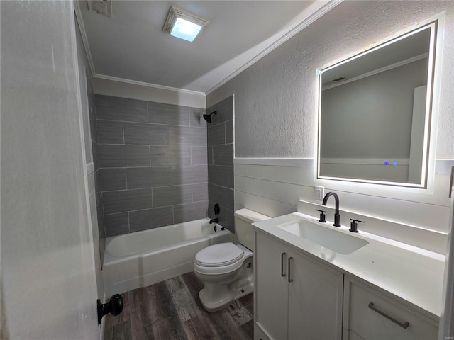 full bathroom featuring ornamental molding, hardwood / wood-style flooring, vanity, toilet, and tiled shower / bath