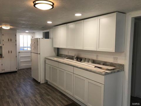 kitchen featuring white cabinetry, dark wood-type flooring, a textured ceiling, and white refrigerator