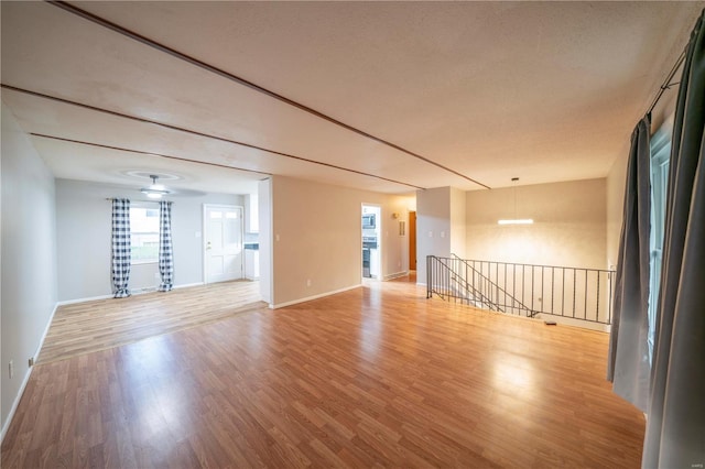 unfurnished room featuring a textured ceiling and light hardwood / wood-style flooring