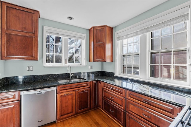 kitchen featuring a healthy amount of sunlight, sink, stainless steel dishwasher, and dark stone counters