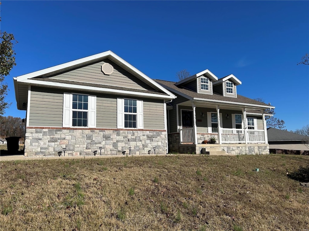 view of front of property with covered porch and a front yard