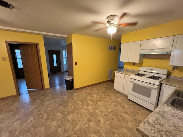 kitchen with light stone countertops, a textured ceiling, white range with gas cooktop, ceiling fan, and white cabinets