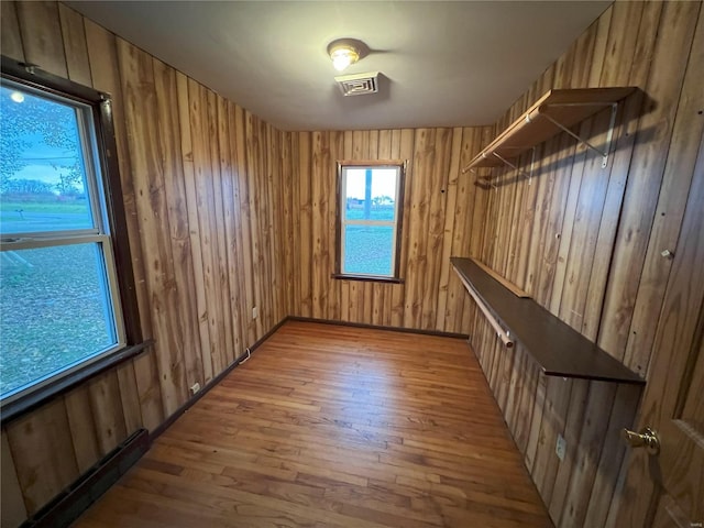 interior space with wood-type flooring and wood walls