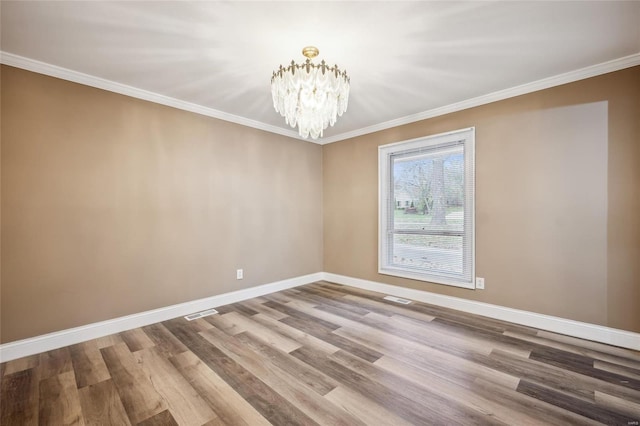 unfurnished room with hardwood / wood-style floors, a notable chandelier, and crown molding