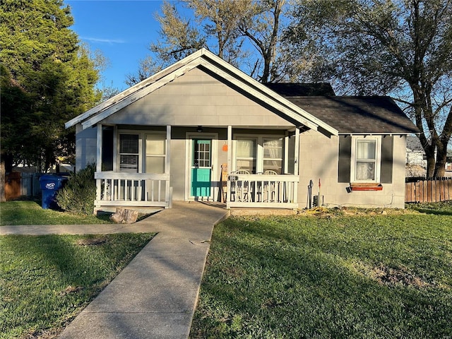 bungalow-style home featuring covered porch and a front yard