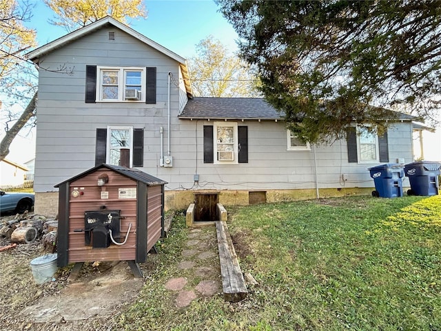 back of house featuring a yard and a shed